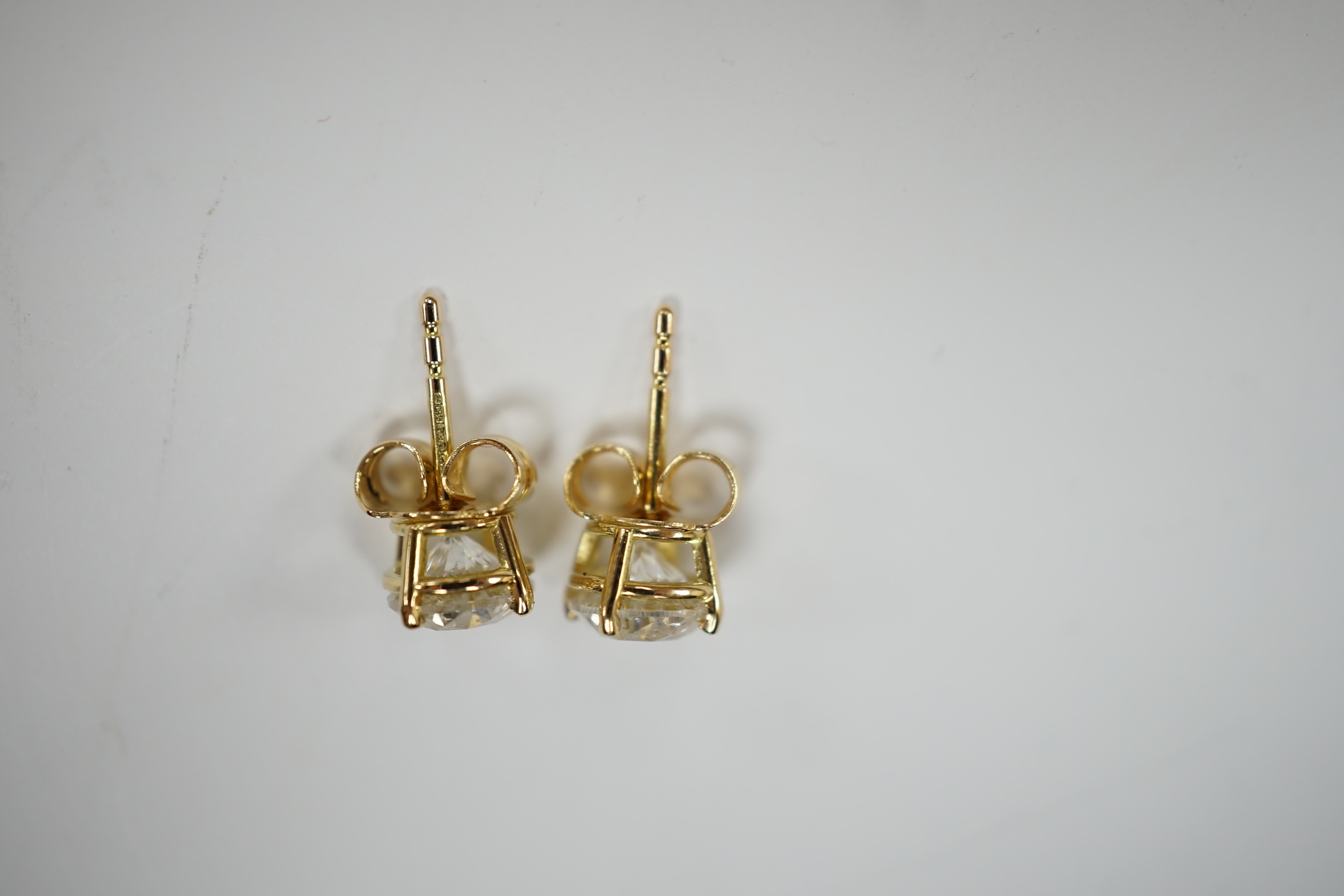 A pair of 750 yellow metal and solitaire diamond set ear studs, with a total carat weight of approximately 1.80ct.
